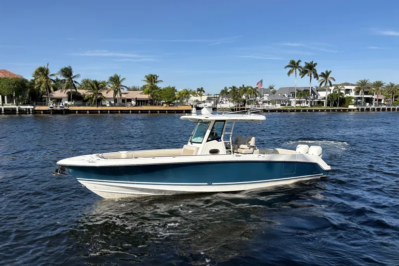  Yacht Photos Pics 2017 Boston Whaler 330 Outrage boat cruising on a sunny day near waterfront homes.