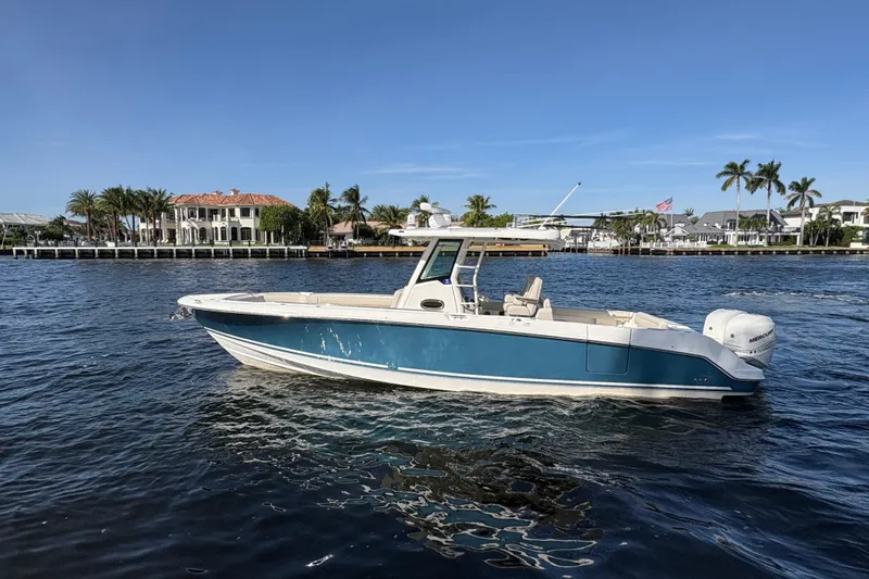  Yacht Photos Pics 2017 Boston Whaler 330 Outrage boat on water, with waterfront homes in the background.