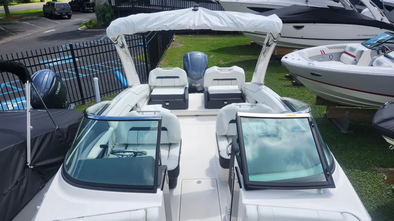  Yacht Photos Pics 2026 Regal LX4 boat with sleek interior, parked outdoors near other boats.