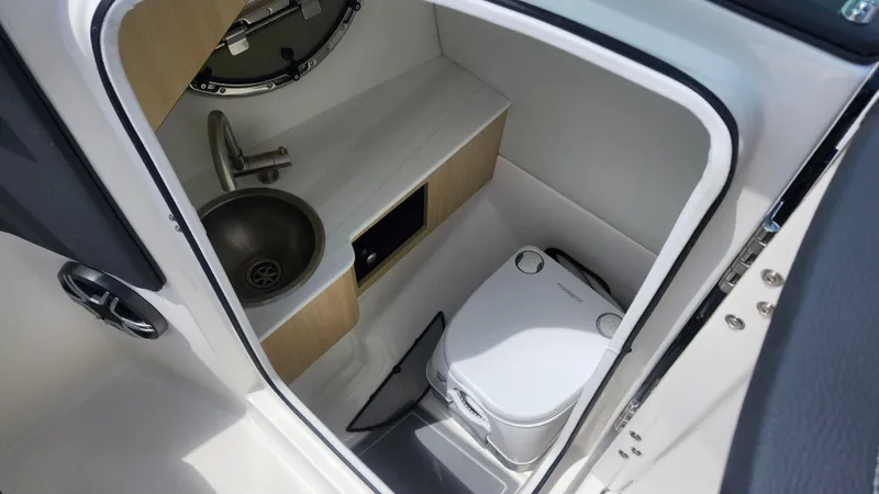  Yacht Photos Pics Compact bathroom in 2026 Regal LX4 boat with sink and portable toilet.