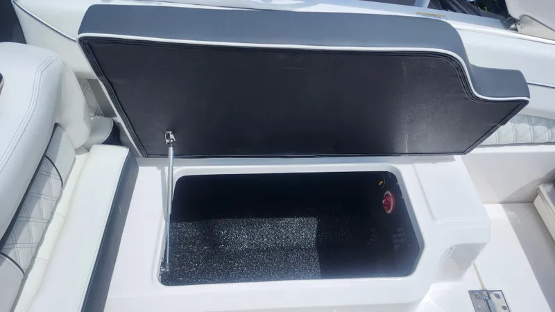  Yacht Photos Pics Open storage compartment on 2026 Regal LX4 boat, featuring sleek white and black design.