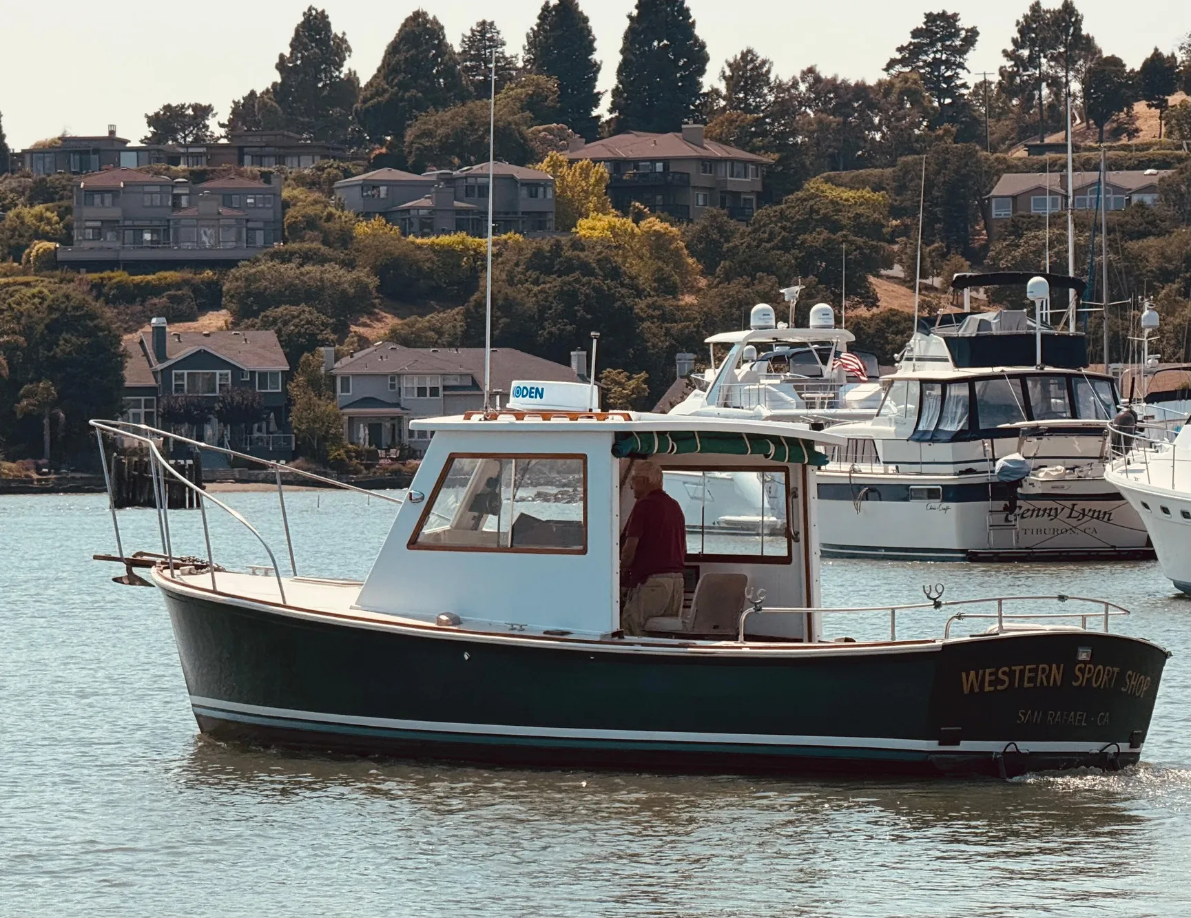 1974 Dyer 29' Sport Fisher boat on calm water, surrounded by houses and other boats.