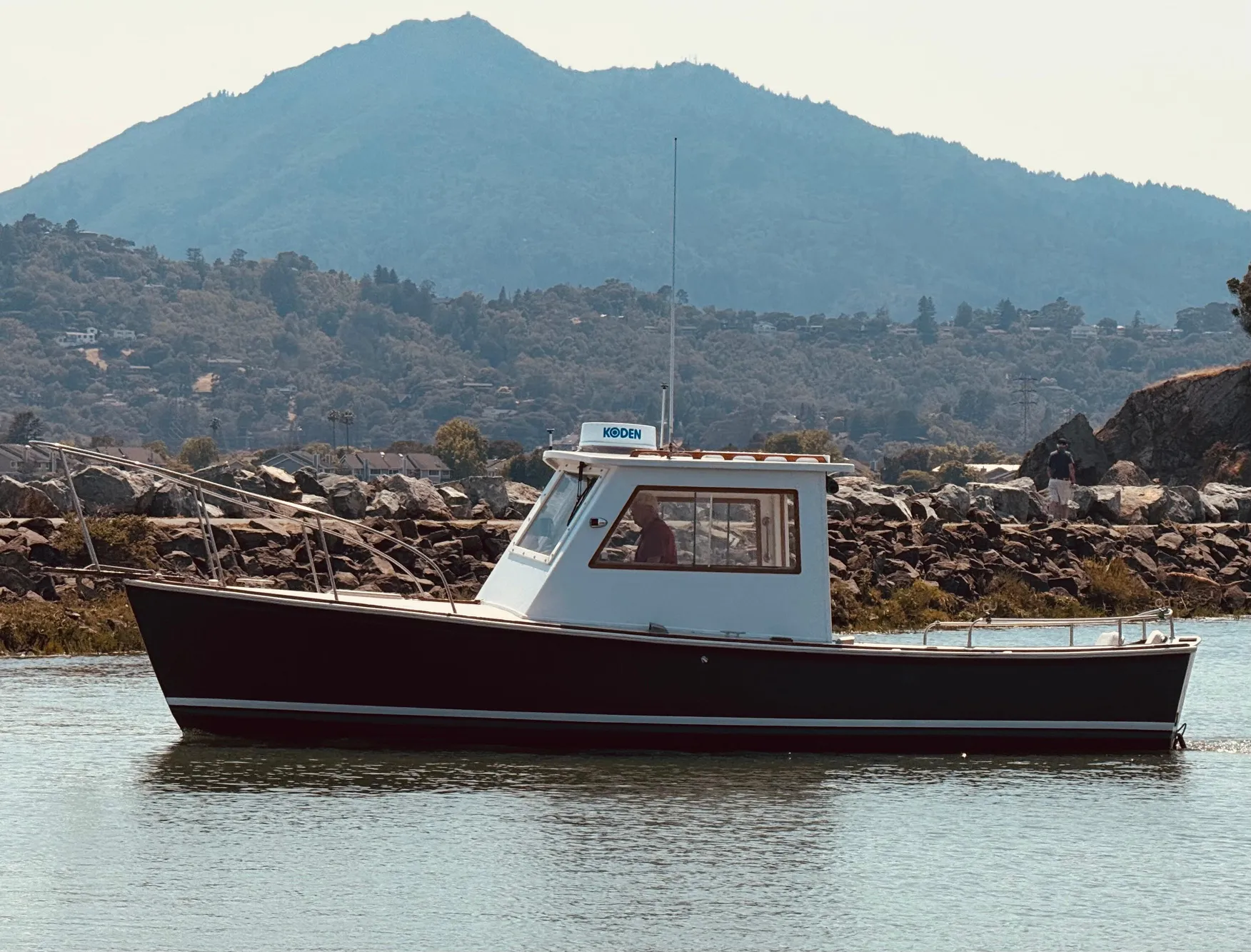 1974 Dyer 29' Sport Fisher boat on calm water with mountainous backdrop.