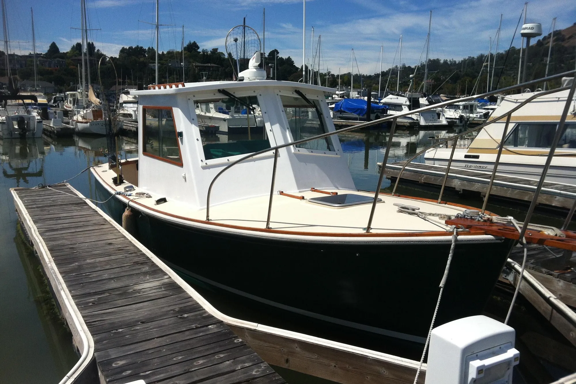 1974 Dyer 29' Sport Fisher boat docked in a marina, surrounded by other vessels.