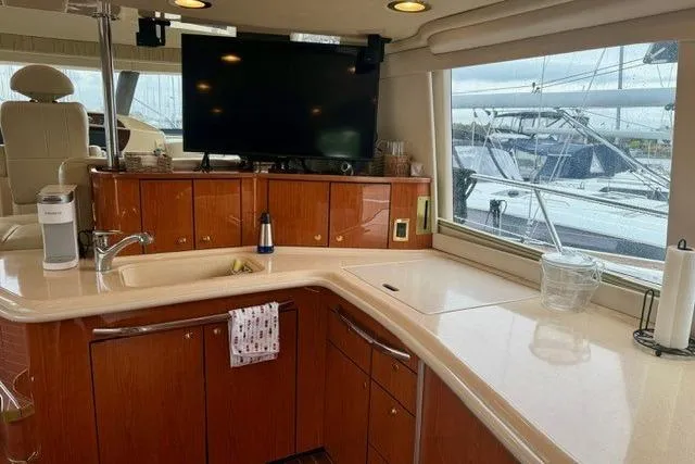  Yacht Photos Pics Luxurious interior of 2001 Sea Ray 540 Cockpit Motor Yacht with kitchen and large window view.