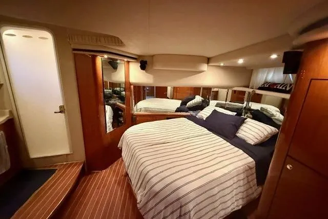  Yacht Photos Pics Luxurious bedroom interior of 2001 Sea Ray 540 Cockpit Motor Yacht with striped bedding.