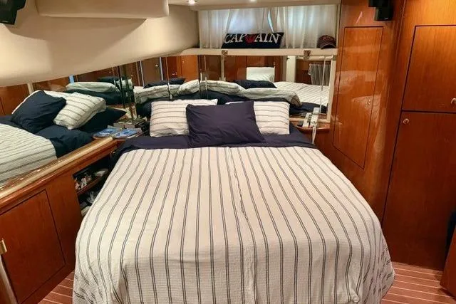  Yacht Photos Pics Luxurious bedroom in 2001 Sea Ray 540 Cockpit Motor Yacht with striped bedding.
