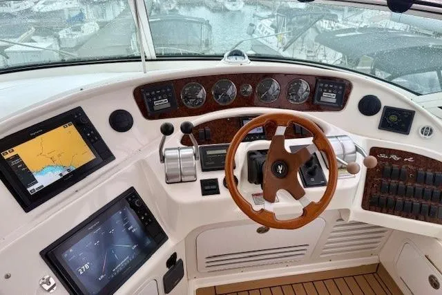  Yacht Photos Pics 2001 Sea Ray 540 Cockpit Motor Yacht helm with navigation screens and wooden steering wheel.