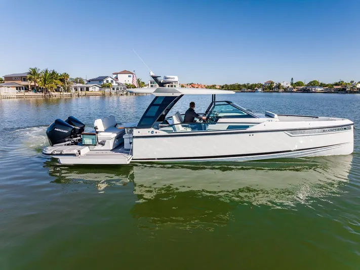  Yacht Photos Pics 2024 Saxdor 320 GTO boat cruising on a calm lake under a clear blue sky.