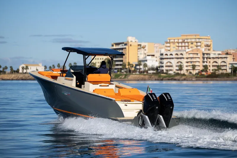  Yacht Photos Pics 2025 AlCustom LIPARI 31 boat cruising on calm water near coastal buildings.