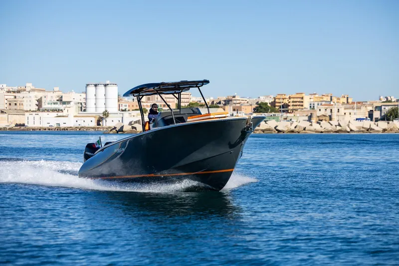  Yacht Photos Pics 2025 AlCustom LIPARI 31 boat cruising on blue water near urban shoreline.