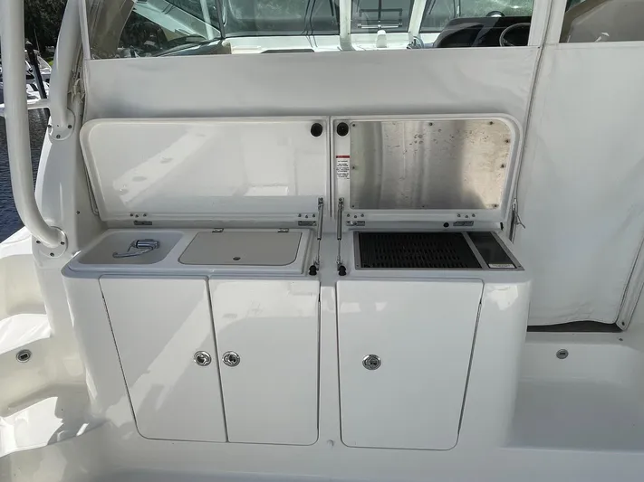  Yacht Photos Pics 2021 Pursuit OS 385 Offshore boat galley with sink and storage compartments.