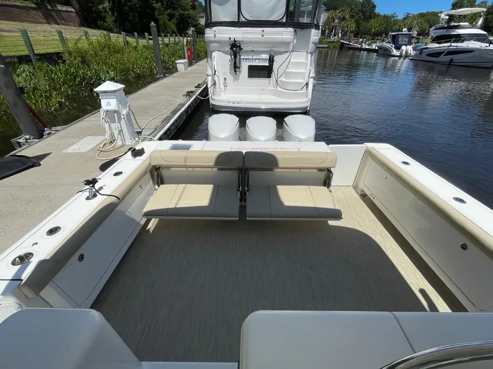  Yacht Photos Pics 2021 Pursuit OS 385 Offshore boat docked, featuring spacious seating and modern design.