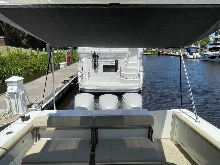  Yacht Photos Pics 2021 Pursuit OS 385 Offshore boat docked, featuring spacious seating and triple outboard engines.