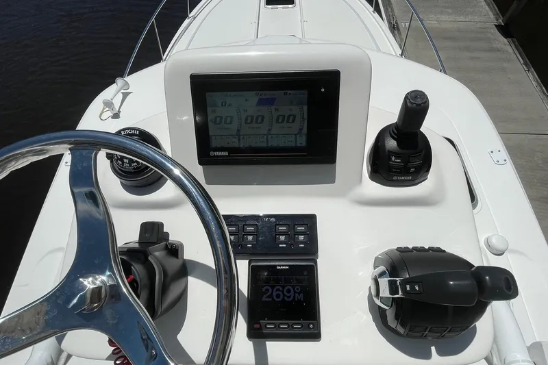  Yacht Photos Pics Control panel of 2021 Pursuit OS 385 Offshore boat with steering wheel and navigation display.