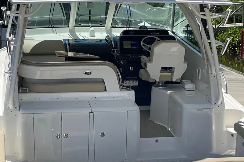  Yacht Photos Pics 2021 Pursuit OS 385 Offshore boat interior with helm, seating, and storage compartments.