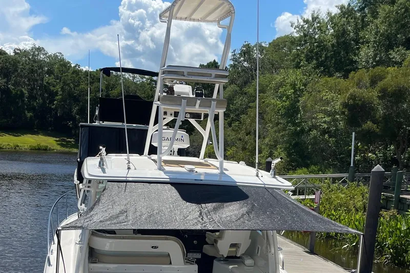  Yacht Photos Pics 2021 Pursuit OS 385 Offshore boat docked by a scenic riverbank.