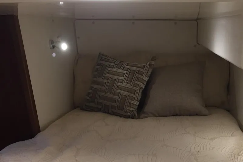  Yacht Photos Pics Cozy cabin interior of 2021 Pursuit OS 385 Offshore with pillows and soft lighting.