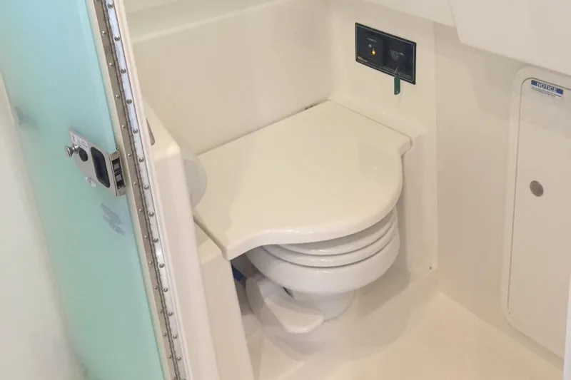 Yacht Photos Pics 2021 Pursuit OS 385 Offshore boat bathroom with compact toilet and control panel.