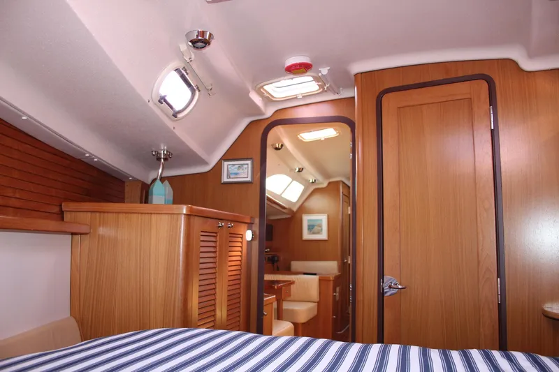 Hannah Yacht Photos Pics Interior of 2011 Catalina 445 sailboat with wood paneling and striped bedding.