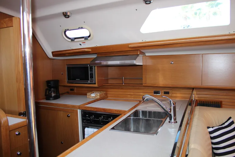 Hannah Yacht Photos Pics 2011 Catalina 445 yacht interior kitchen with wooden cabinetry, sink, and appliances.