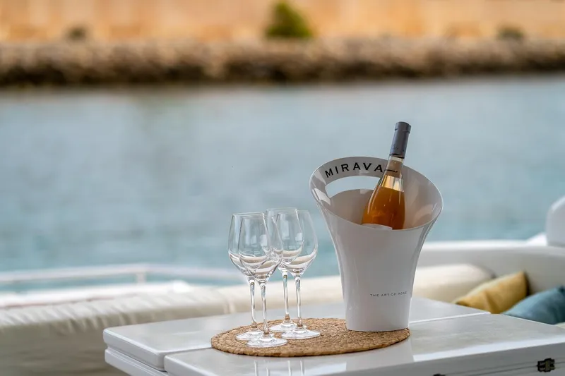  Yacht Photos Pics Wine and glasses on Filippetti S55S yacht, 2020 model, with serene water backdrop.