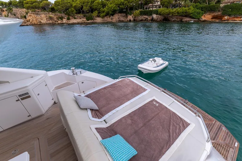  Yacht Photos Pics Luxurious 2020 Filippetti S55S yacht deck with sun loungers, overlooking serene coastal waters.