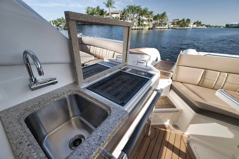  Yacht Photos Pics Luxury 2016 Sea Ray 350 SLX boat with outdoor sink and grill, docked by scenic waterfront.