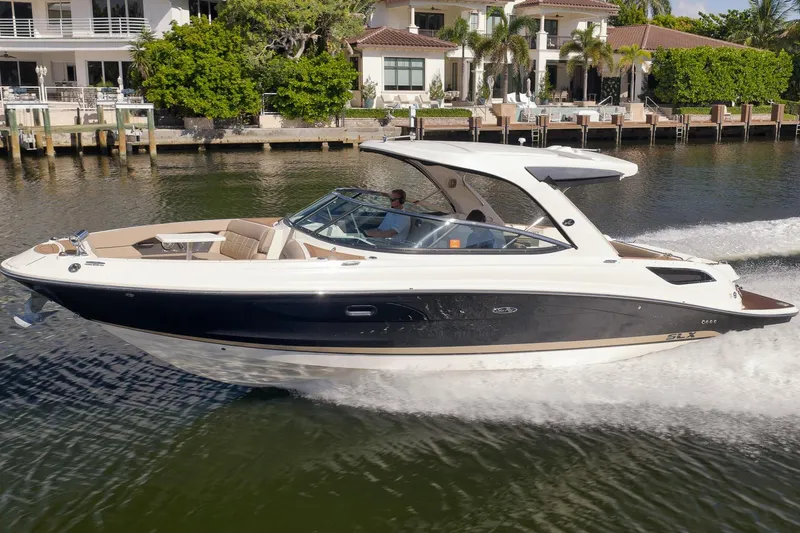  Yacht Photos Pics 2016 Sea Ray 350 SLX cruising on a sunny waterfront near luxury homes.