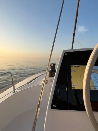  Yacht Photos Pics Sailing on a 2023 Bali 4.6 catamaran at sunrise, featuring navigation display.