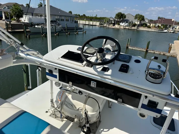  Yacht Photos Pics 2000 Cabo 31 Express boat helm with steering wheel and controls, docked in a marina.