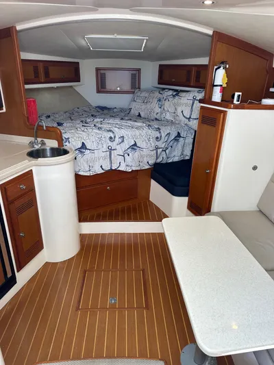  Yacht Photos Pics Interior of 2000 Cabo 31 Express boat with cozy cabin and nautical decor.