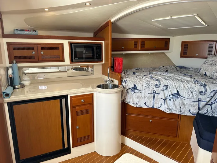  Yacht Photos Pics Interior of 2000 Cabo 31 Express boat with kitchenette and cozy sleeping area.