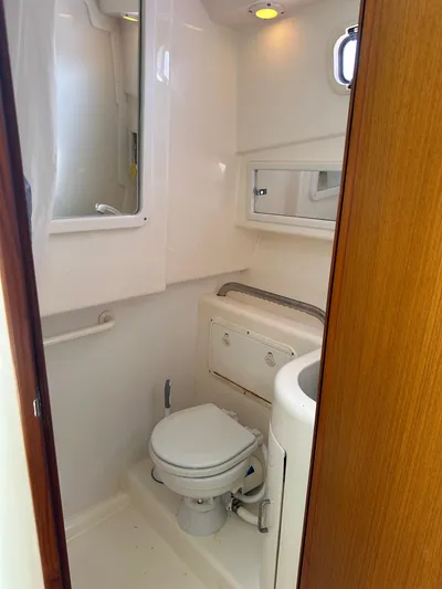  Yacht Photos Pics 2000 Cabo 31 Express boat bathroom with toilet, sink, and mirror.