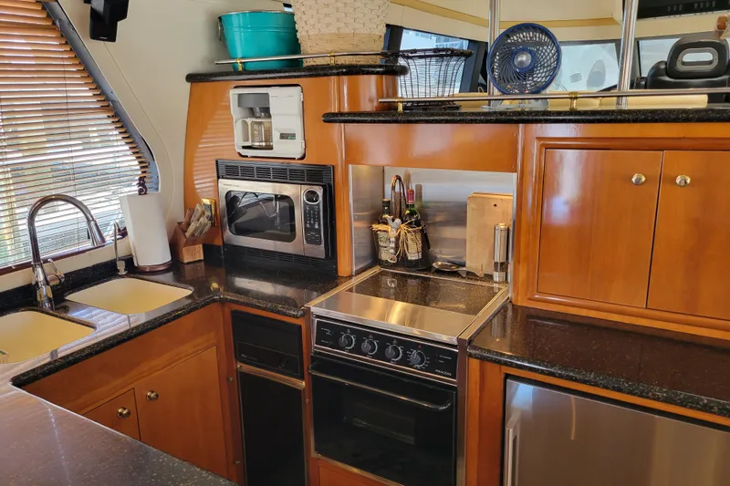  Yacht Photos Pics Kitchen area of 2001 Carver 570 Voyager Pilothouse with modern appliances and wooden cabinetry.