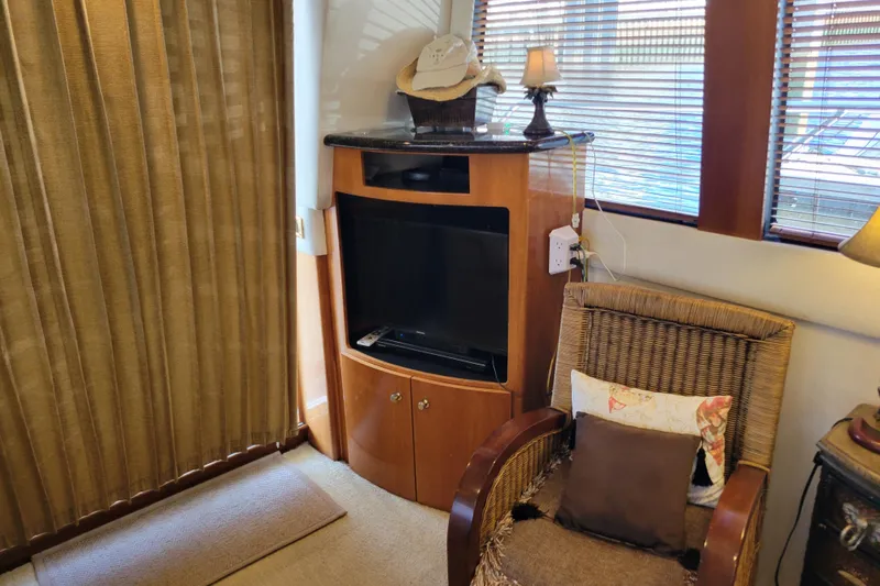  Yacht Photos Pics Interior of 2001 Carver 570 Voyager Pilothouse with TV, wicker chair, and decor.