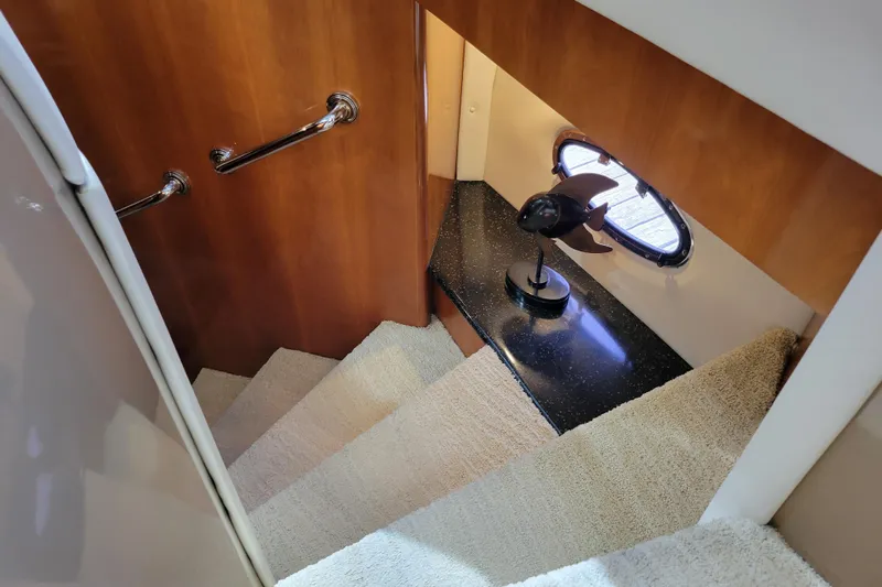  Yacht Photos Pics Staircase in 2001 Carver 570 Voyager Pilothouse with wooden paneling and decorative lamp.