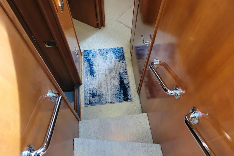  Yacht Photos Pics Staircase inside 2001 Carver 570 Voyager Pilothouse with wooden walls and blue rug.