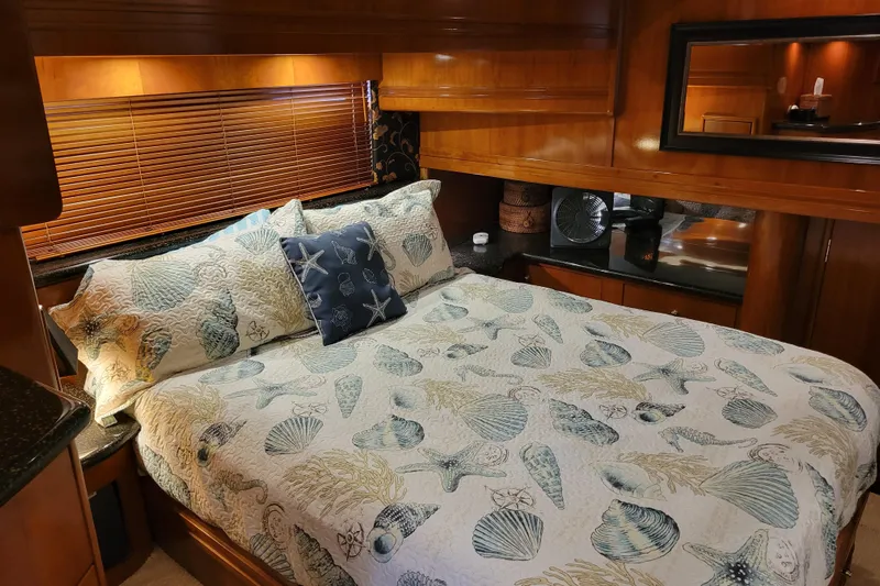  Yacht Photos Pics Luxurious bedroom interior of 2001 Carver 570 Voyager Pilothouse yacht with seashell-themed bedding.