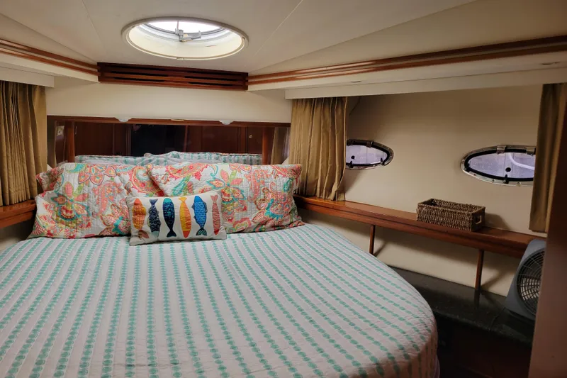  Yacht Photos Pics Cozy bedroom in 2001 Carver 570 Voyager Pilothouse with colorful bedding and porthole windows.