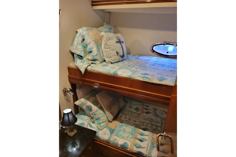  Yacht Photos Pics Bunk beds in 2001 Carver 570 Voyager Pilothouse with nautical-themed bedding and porthole window.