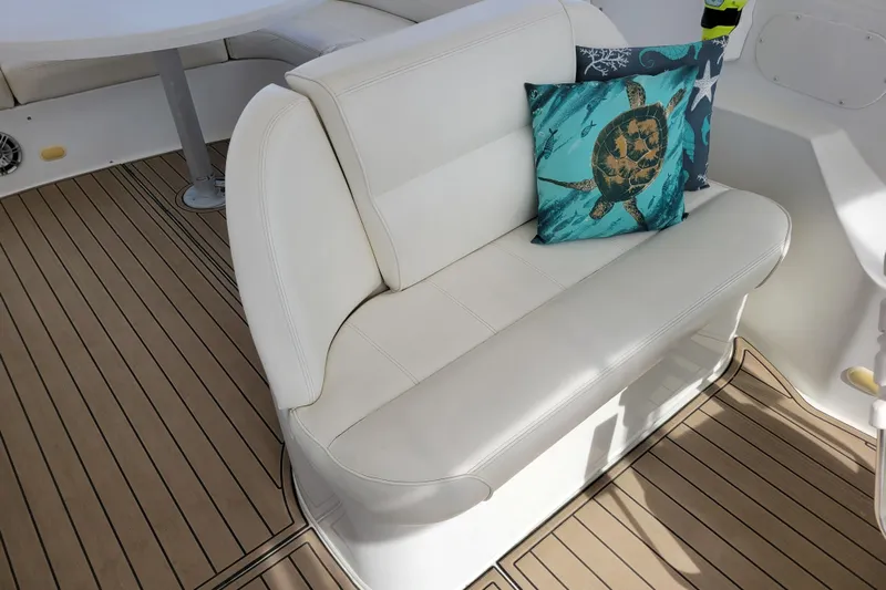  Yacht Photos Pics White seating with turtle-themed cushion on 2001 Carver 570 Voyager Pilothouse yacht deck.
