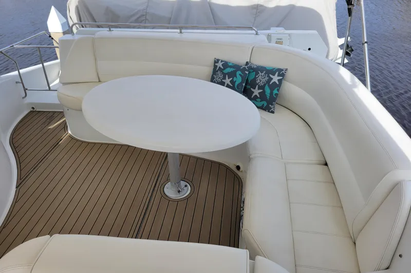  Yacht Photos Pics Luxurious seating area on 2001 Carver 570 Voyager Pilothouse yacht with white cushions and table.
