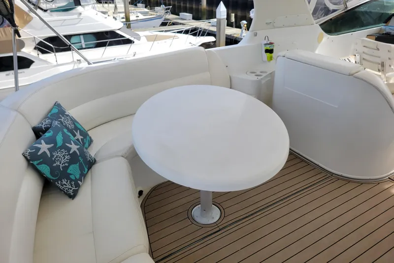  Yacht Photos Pics Luxurious seating area on 2001 Carver 570 Voyager Pilothouse yacht with round table and cushions.