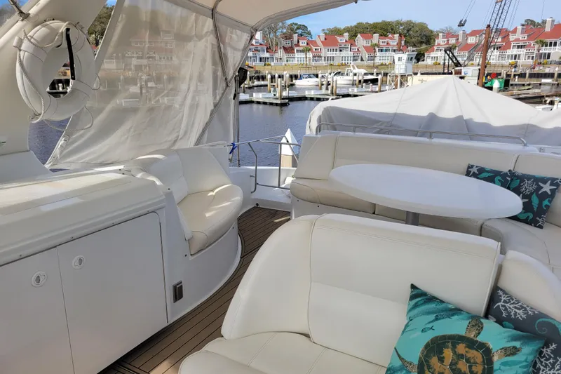  Yacht Photos Pics Luxurious 2001 Carver 570 Voyager Pilothouse yacht interior with white seating and decorative pillows.