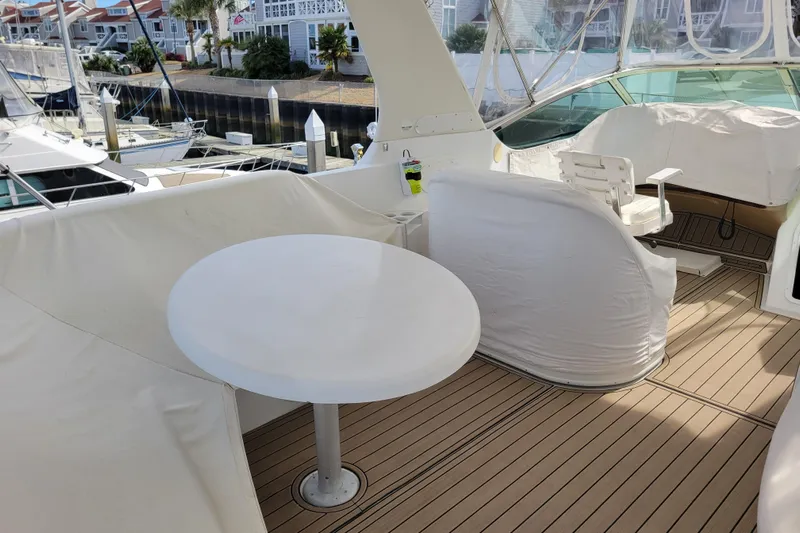  Yacht Photos Pics 2001 Carver 570 Voyager Pilothouse yacht deck with seating and table, docked at marina.