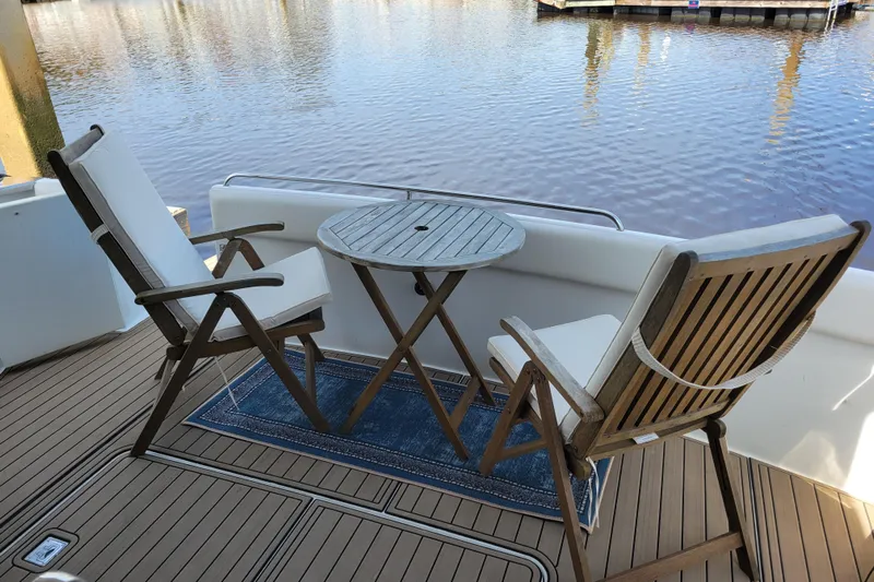  Yacht Photos Pics Outdoor seating on 2001 Carver 570 Voyager Pilothouse yacht, overlooking serene water.