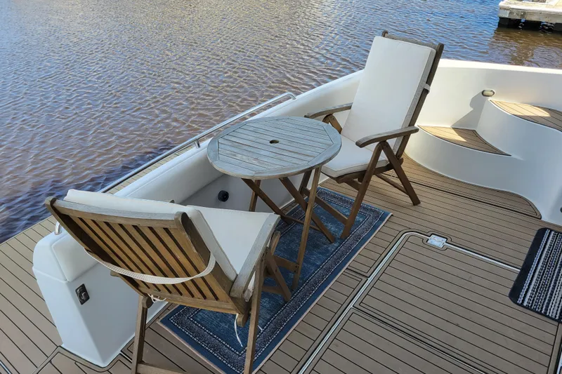  Yacht Photos Pics Deck of 2001 Carver 570 Voyager Pilothouse with chairs and table by the water.