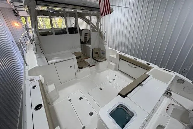  Yacht Photos Pics 2021 Pursuit OS 355 Offshore boat interior with seating and storage in a covered dock.