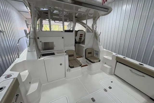  Yacht Photos Pics 2021 Pursuit OS 355 Offshore boat interior with seating and storage in a metal-walled space.